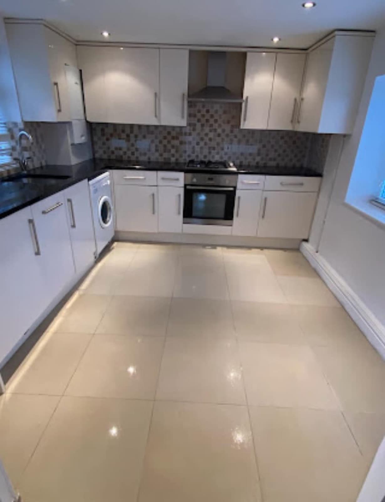 A cleaned kitchen with polished tiled flooring